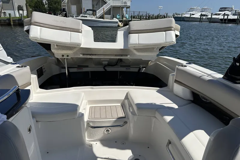 Slide: The Image of 2012 Sea Ray SLX 250 boat interior with open engine compartment, docked by the water. - 7