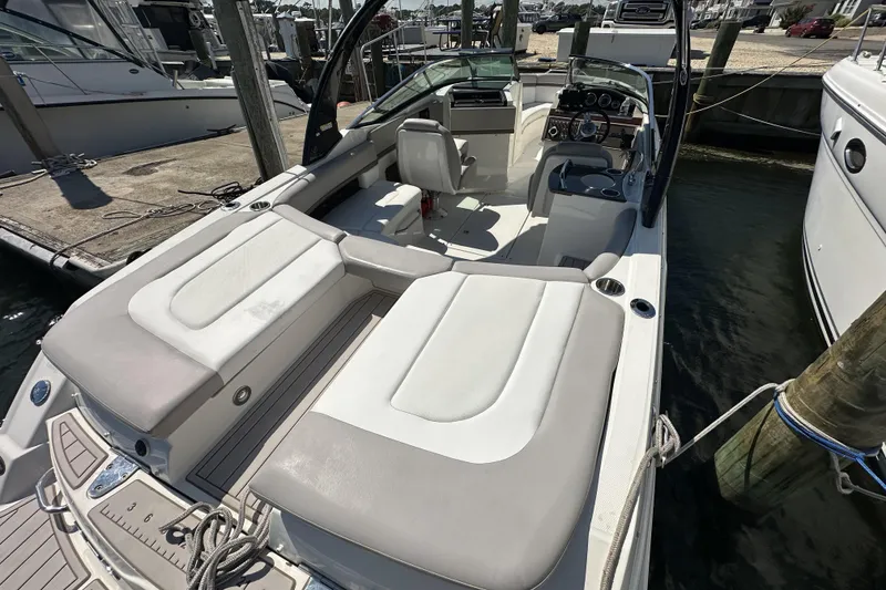 Slide: The Image of 2012 Sea Ray SLX 250 boat docked, featuring spacious seating and modern dashboard. - 14