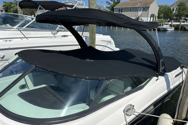 Slide: The Image of 2012 Sea Ray SLX 250 boat with black canopy docked in marina. - 19