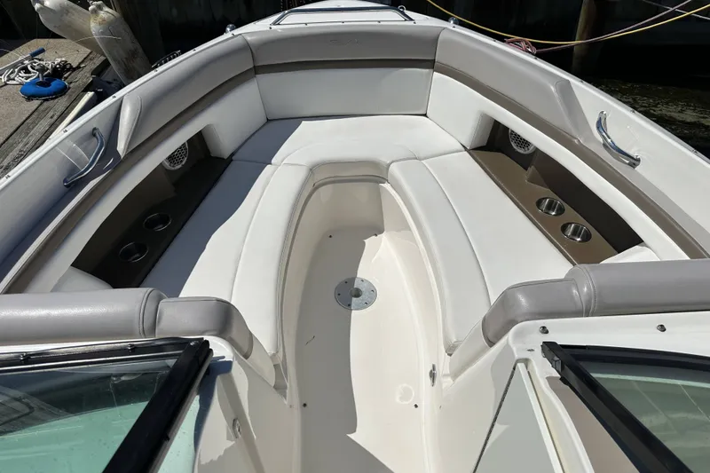 Slide: The Image of Interior view of a 2012 Sea Ray SLX 250 boat with white seating and cup holders. - 9