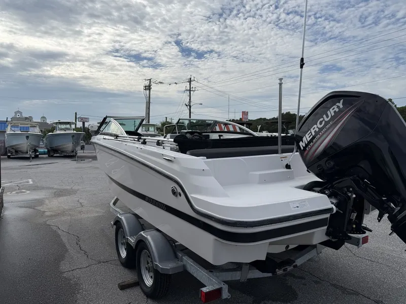 Slide: The Image of A 2019 Four Winns HD 200 Freedom on a trailer, featuring a Mercury outboard motor. - 5