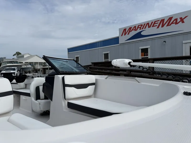 Slide: The Image of The image shows a 2019 Four Winns HD 200 Freedom boat with white seating and black accents. It is located at a marina with a MarineMax building in the background. - 22