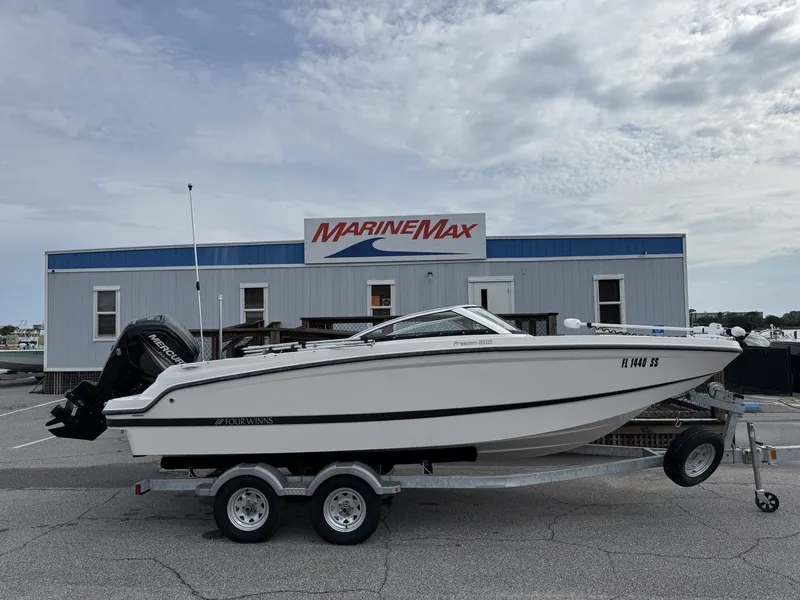 Slide: The Image of A white 2019 Four Winns HD 200 Freedom boat on a trailer in front of a building. - 0