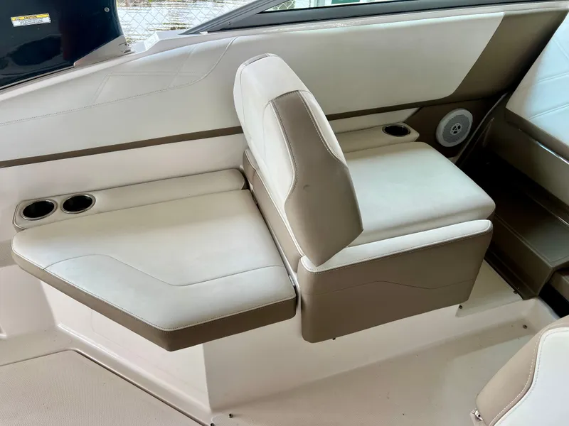 Slide: The Image of Interior view of a 2017 Regal 26 Express boat featuring a beige bench seat with cup holders. - 9