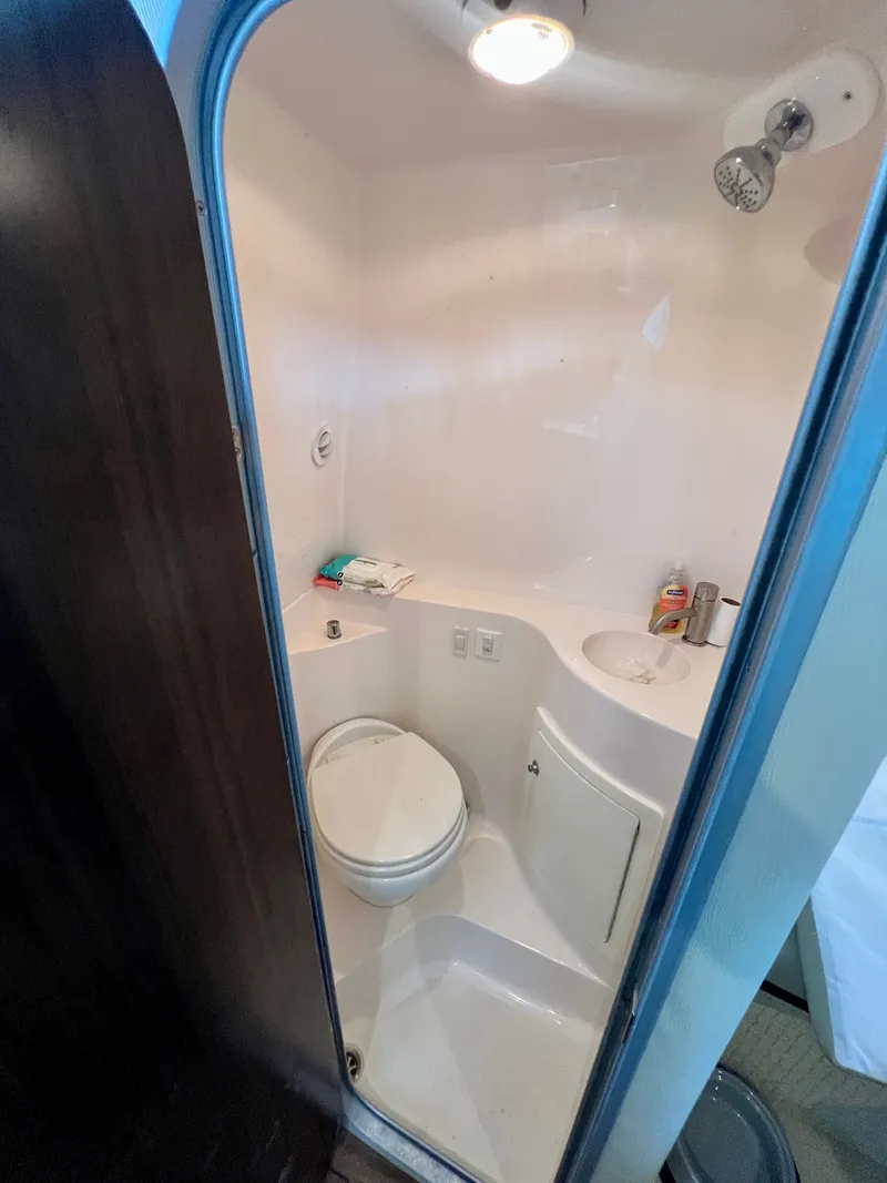 Slide: The Image of The image shows a compact boat bathroom with a toilet, sink, and shower. - 18