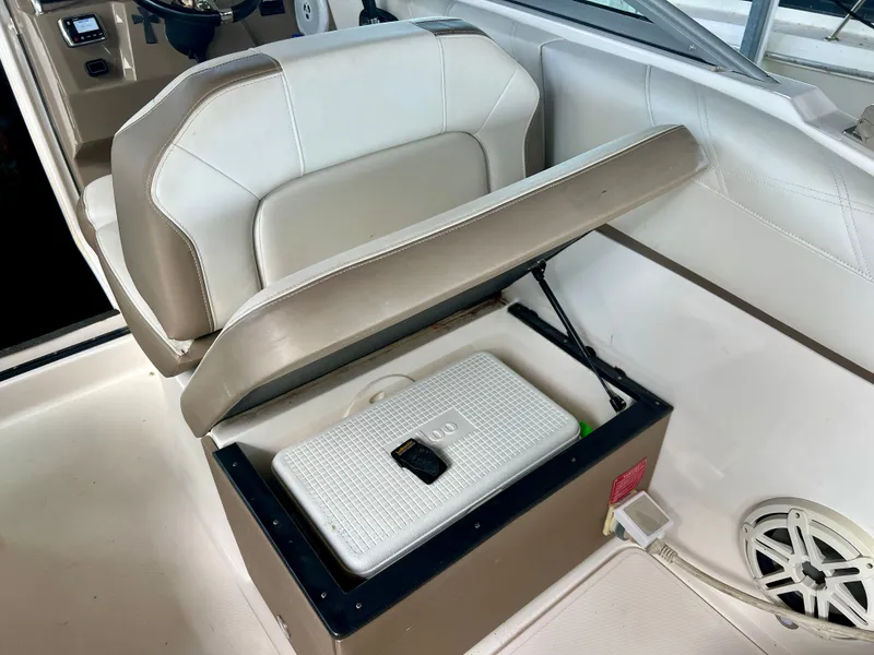 Slide: The Image of A seat on a 2017 Regal 26 Express boat is lifted to reveal storage underneath. - 15