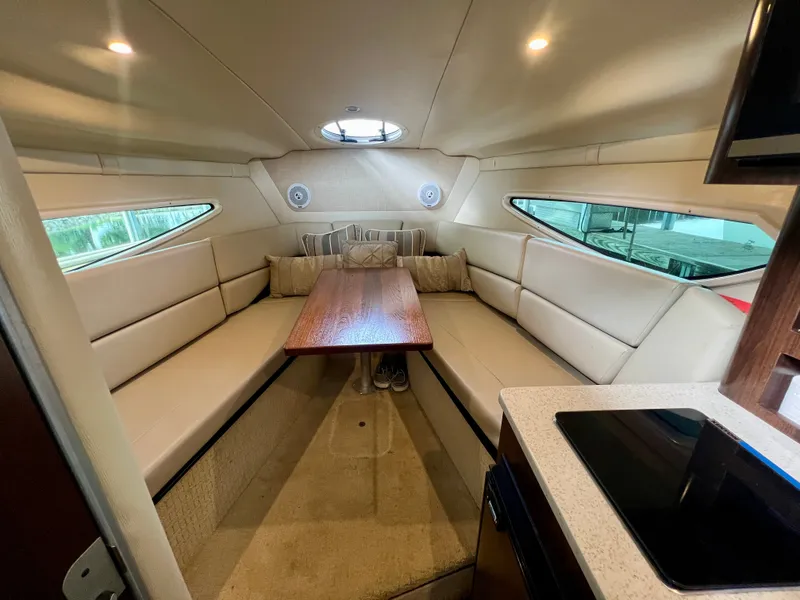 Slide: The Image of The 2017 Regal 26 Express cabin features a cozy seating area with a wooden table. - 20
