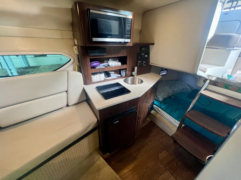 Slide: The Image of The cabin of a 2017 Regal 26 Express features a compact kitchen with a microwave and sink. - 16