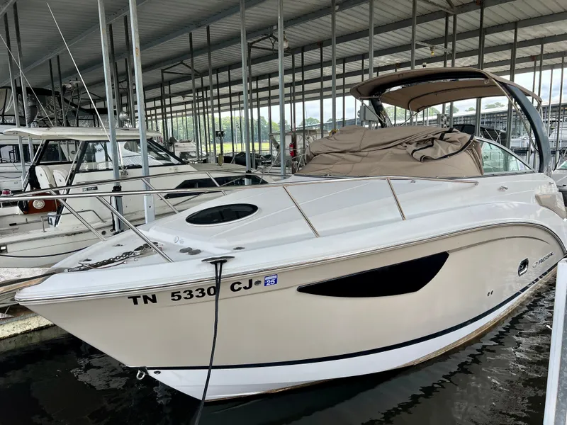 Slide: The Image of A 2017 Regal 26 Express boat docked in a covered marina. It features a sleek design. - 0