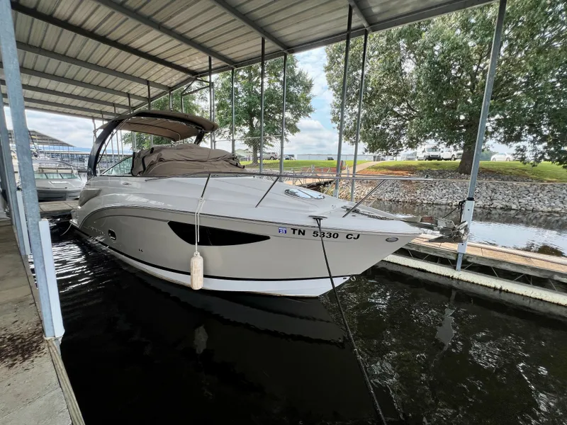 The Image of A 2017 Regal 26 Express boat is docked under a covered area by the water. - 3
