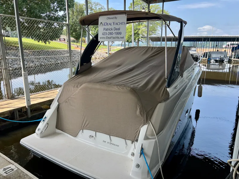 Slide: The Image of A 2017 Regal 26 Express boat is docked under a cover, with a protective tarp over it. - 23