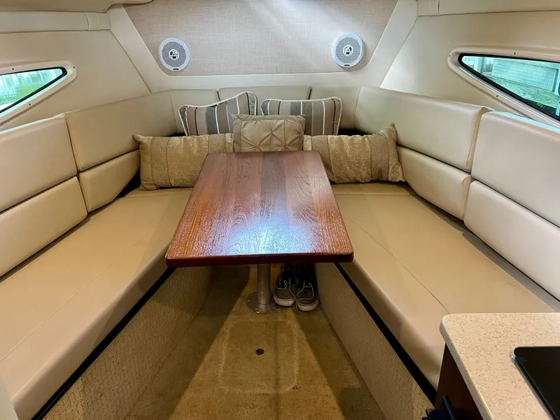 Slide: The Image of Interior of a 2017 Regal 26 Express with beige upholstery and a wooden table. - 19