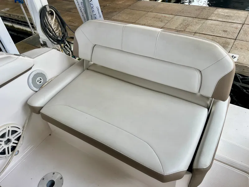 Slide: The Image of A white and beige cushioned seat on a boat, with a speaker and dock in the background. - 8