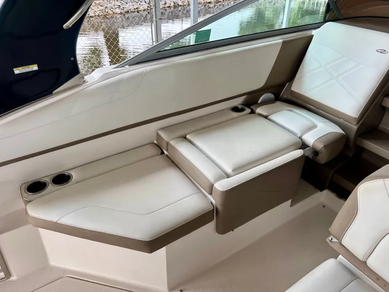 Slide: The Image of The 2017 Regal 26 Express interior features comfortable cream-colored seating with cup holders. - 10