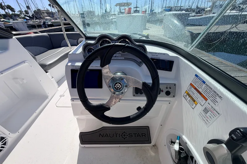 Slide: The Image of Steering console of 2026 NauticStar 203 DC Deck boat at marina. - 11