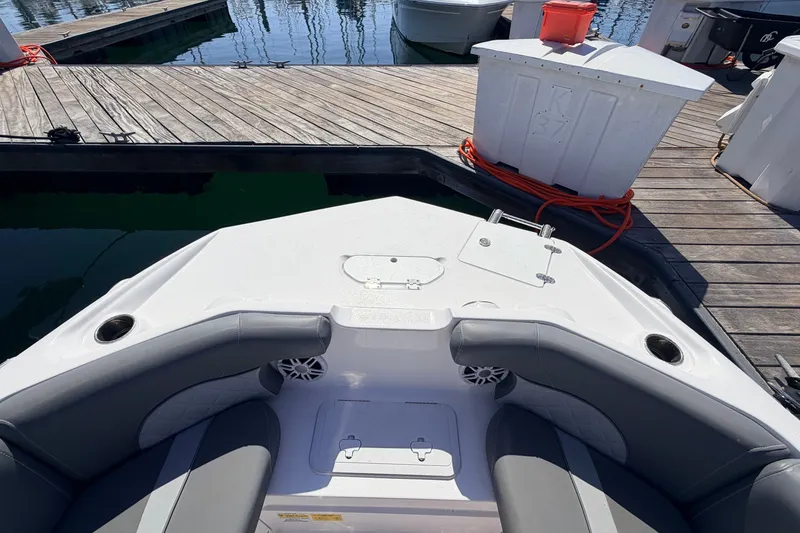 Slide: The Image of 2026 NauticStar 203 DC Deck boat interior at dock, featuring seating and cup holders. - 24