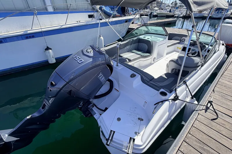 Slide: The Image of 2026 NauticStar 203 DC Deck boat with Yamaha 150 engine docked at marina. - 4