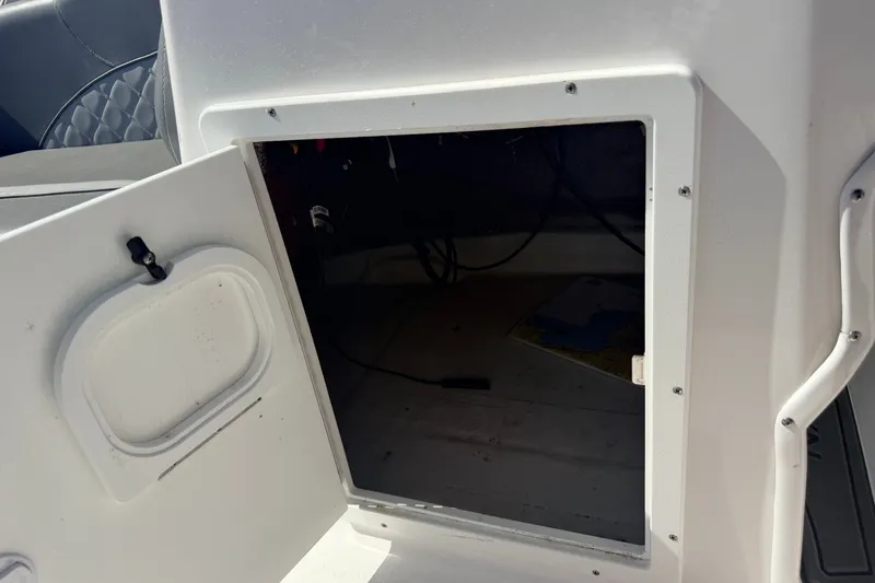 Slide: The Image of Open storage compartment on 2026 NauticStar 203 DC Deck boat. - 19
