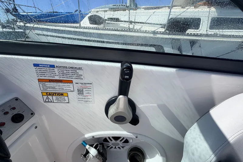 Slide: The Image of Control panel of a 2026 NauticStar 203 DC Deck boat with safety notices. - 12