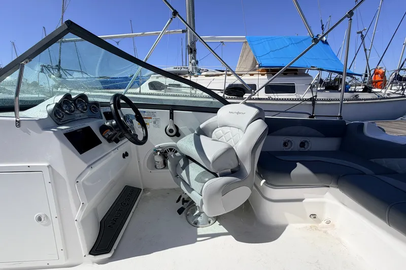 Slide: The Image of 2026 NauticStar 203 DC Deck boat interior with steering wheel and seating. - 9