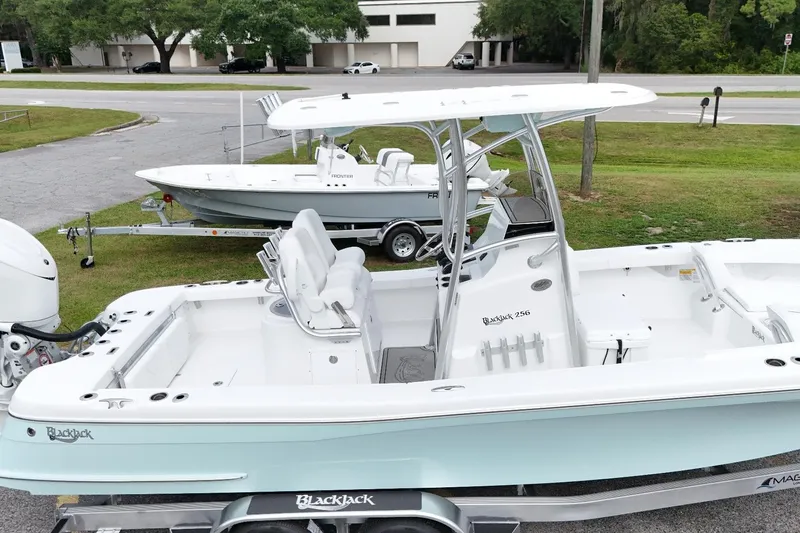 Slide: The Image of 2027 BlackJack 256 Coastal boat on trailer, parked outdoors near road. - 1