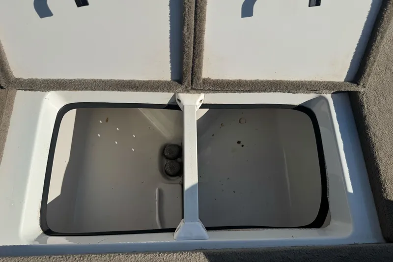 Slide: The Image of Open storage compartment in a 2004 Ranger 185 VS boat, featuring carpeted edges. - 23