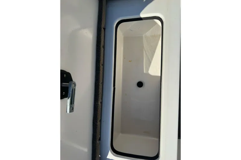 Slide: The Image of Storage compartment of a 2004 Ranger 185 VS boat, featuring a latch and drain hole. - 19