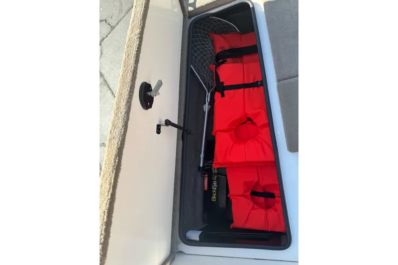 Slide: The Image of Storage compartment of a 2004 Ranger 185 VS boat with red life jackets and a fishing net. - 18