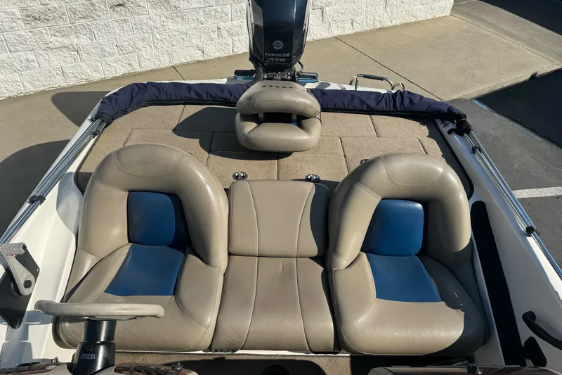 Slide: The Image of 2004 Ranger 185 VS boat interior with beige and blue seating, steering wheel, and motor. - 11
