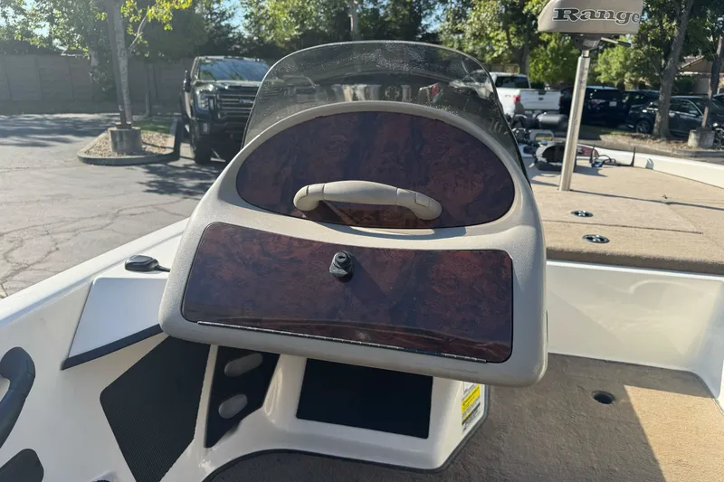 Slide: The Image of 2004 Ranger 185 VS boat dashboard with wood paneling and steering wheel. - 16