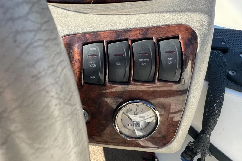 Slide: The Image of Dashboard controls of a 2004 Ranger 185 VS boat with switches and fuel gauge. - 14