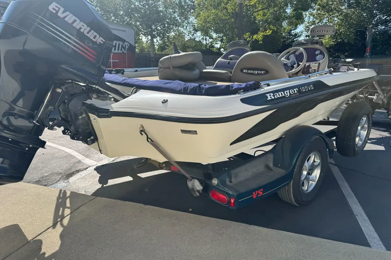 Slide: The Image of 2004 Ranger 185 VS boat with Evinrude motor on trailer, parked outdoors. - 4