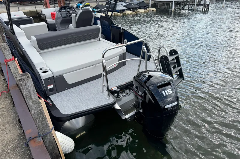 Slide: The Image of 2027 Harris Sunliner 210 pontoon boat with Mercury 115 engine docked by the water. - 4