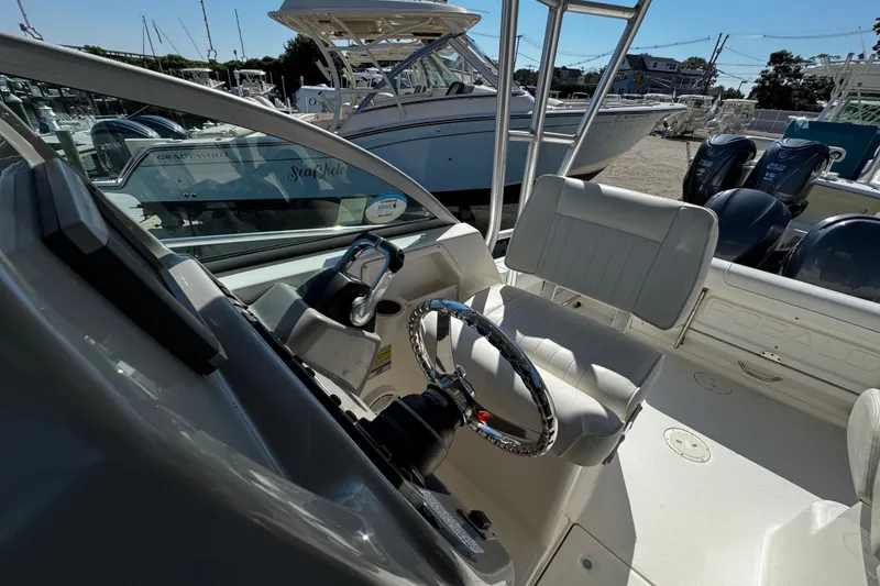Slide: The Image of 2010 Robalo R265 Walkaround boat interior with steering wheel and seating area. - 23