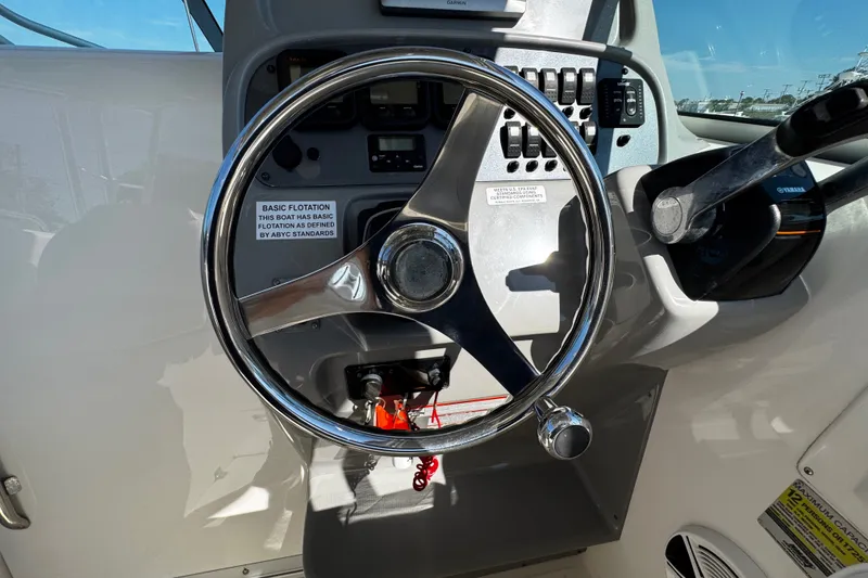 Slide: The Image of Steering wheel and controls of a 2010 Robalo R265 Walkaround boat cockpit. - 29