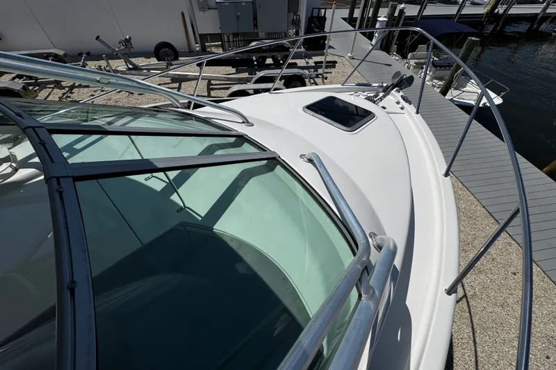 Slide: The Image of 2010 Robalo R265 Walkaround boat docked, showcasing sleek design and sturdy railings. - 48