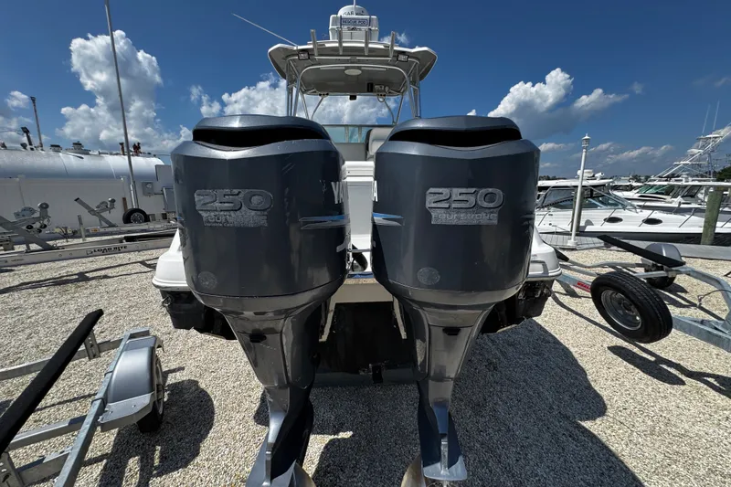 Slide: The Image of 2010 Robalo R265 Walkaround with twin Yamaha 250 outboard engines, docked under a clear sky. - 54