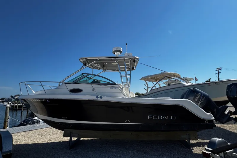 Slide: The Image of 2010 Robalo R265 Walkaround boat on display at a marina. - 3
