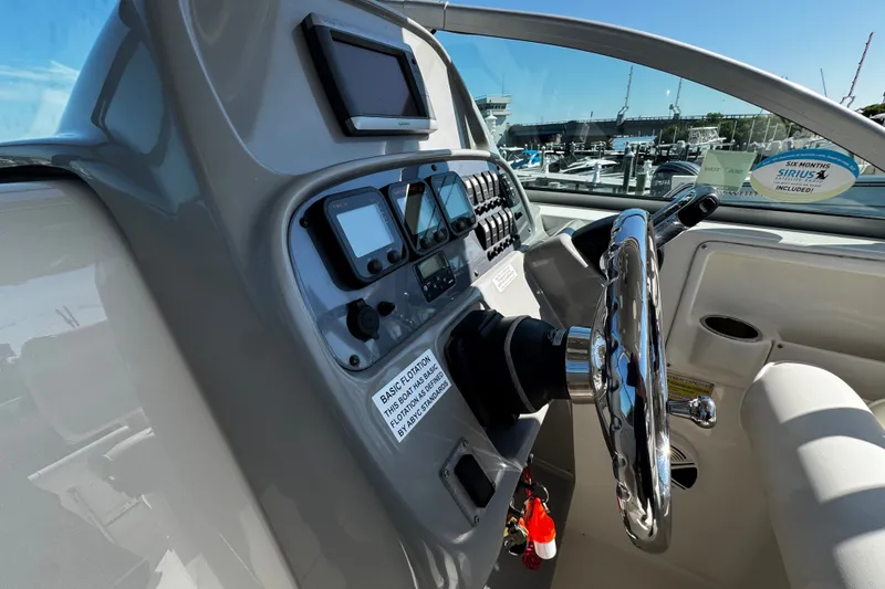 Slide: The Image of 2010 Robalo R265 Walkaround boat dashboard with steering wheel and navigation controls. - 30