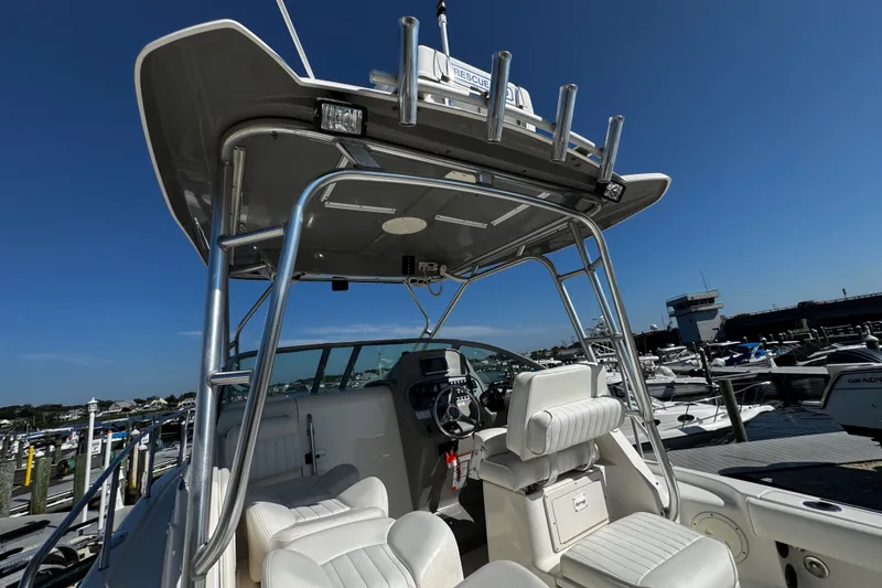 Slide: The Image of 2010 Robalo R265 Walkaround boat interior at marina, showcasing helm and seating. - 41