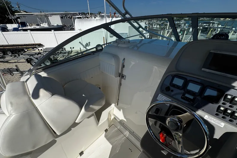 Slide: The Image of 2010 Robalo R265 Walkaround boat cockpit with steering wheel and control panel. - 33