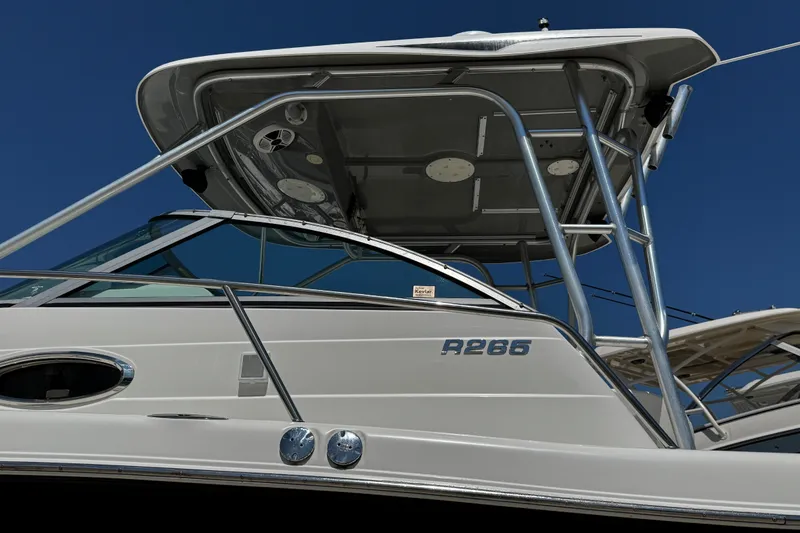 Slide: The Image of 2010 Robalo R265 Walkaround boat with sleek design and sturdy framework against a clear blue sky. - 55