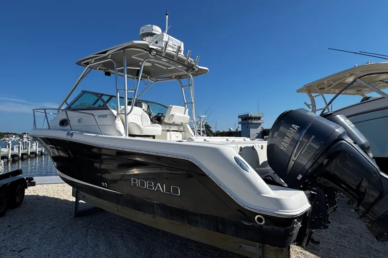 Slide: The Image of 2010 Robalo R265 Walkaround boat with Yamaha engine, docked under clear blue sky. - 4