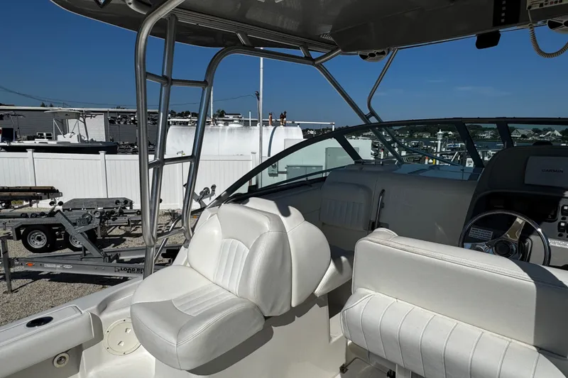 Slide: The Image of 2010 Robalo R265 Walkaround boat interior with white seating and steering console. - 9