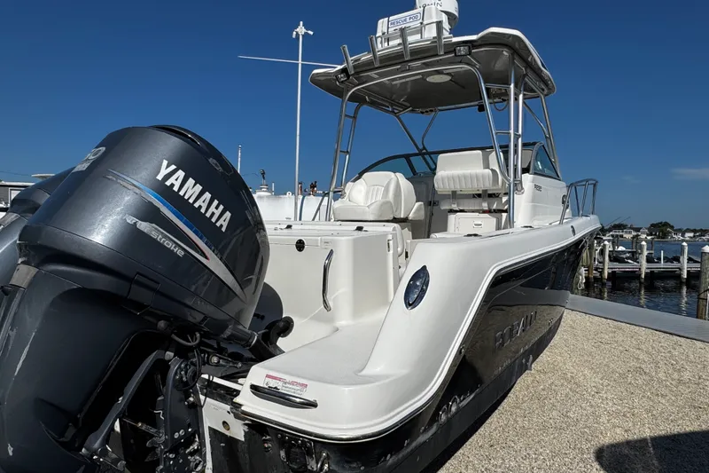 Slide: The Image of 2010 Robalo R265 Walkaround boat with Yamaha engine, docked under clear blue sky. - 5