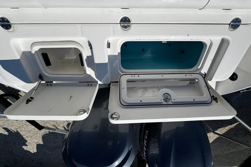 Slide: The Image of 2010 Robalo R265 Walkaround boat storage compartments with open hatches. - 14