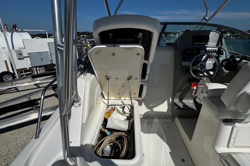 Slide: The Image of 2010 Robalo R265 Walkaround boat interior with open storage compartment and steering wheel. - 37
