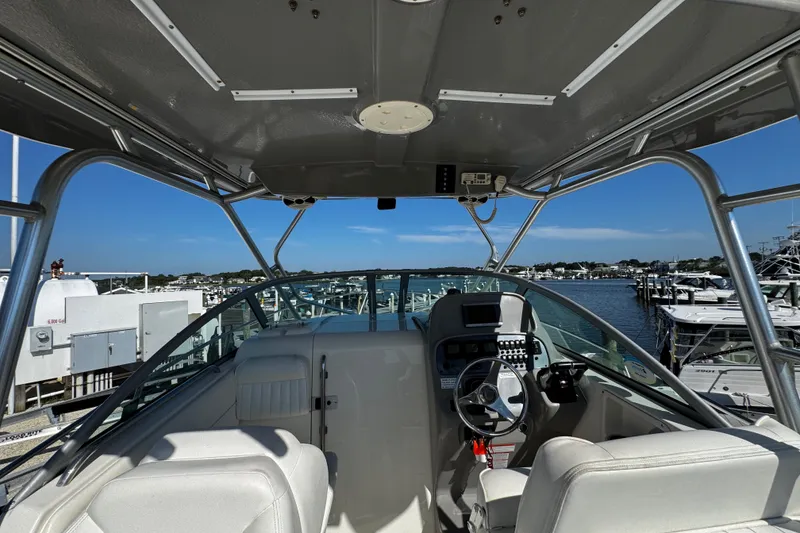 Slide: The Image of 2010 Robalo R265 Walkaround boat interior with steering wheel, docked at marina. - 35
