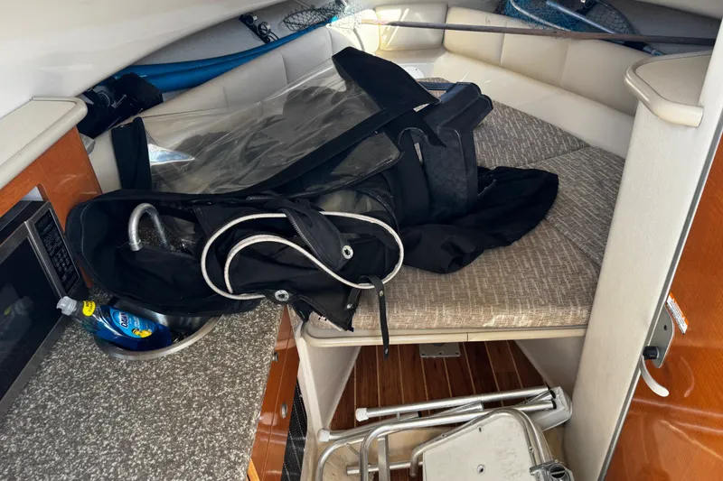 Slide: The Image of Interior of 2010 Robalo R265 Walkaround boat with gear and supplies on cabin bed. - 43