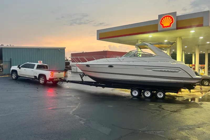 Slide: The Image of White truck towing 2000 Maxum 3200 SCR boat at Shell gas station during sunset. - 25